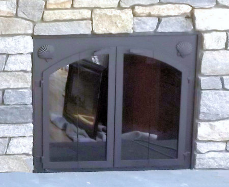 Allison fireplace doors inside fit on stone  All black finish with vice bi fold doors and standard smoke glass comes with sliding mesh spark screen